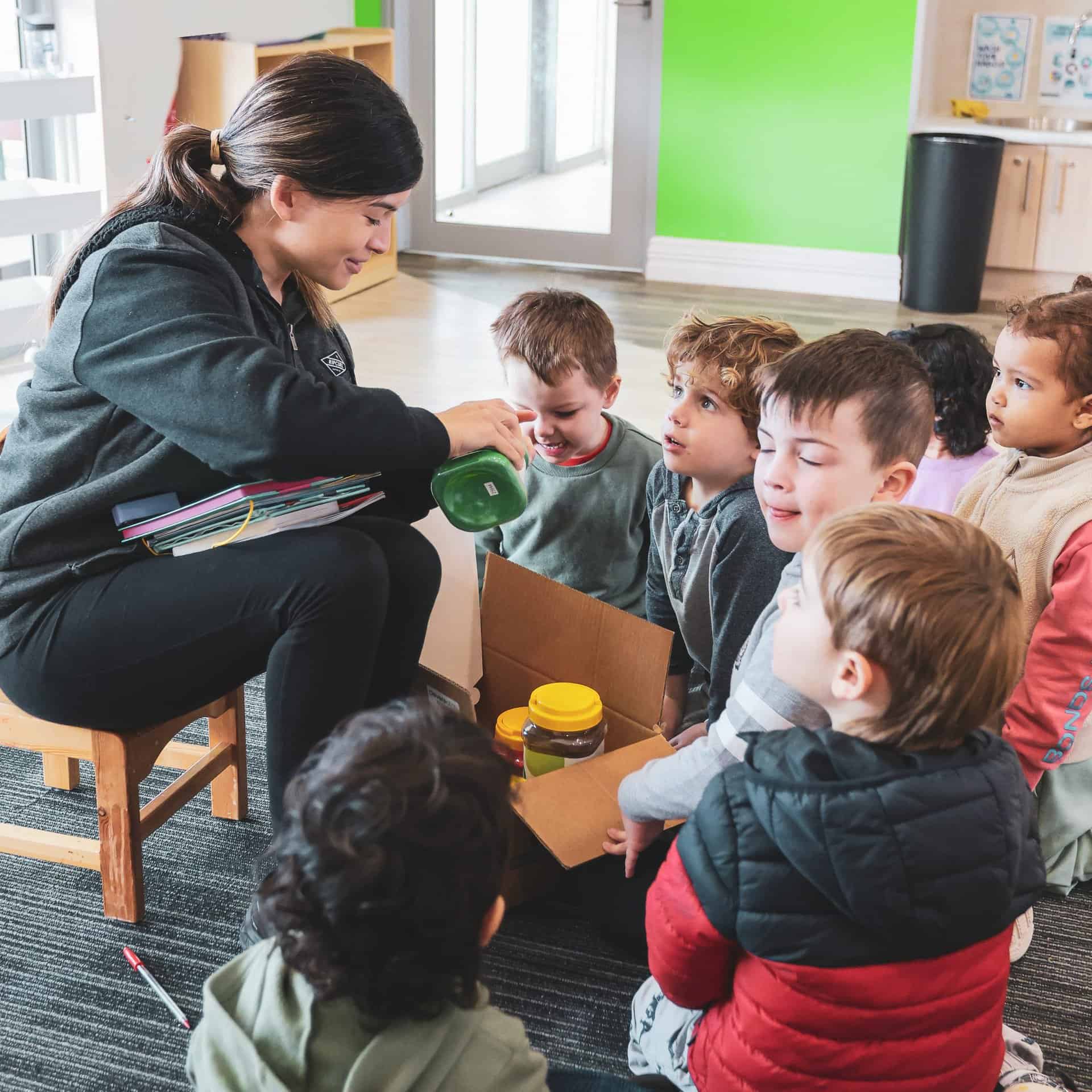 Group of children with a kindergarten teacher doing arts and crafts at a childcare centre